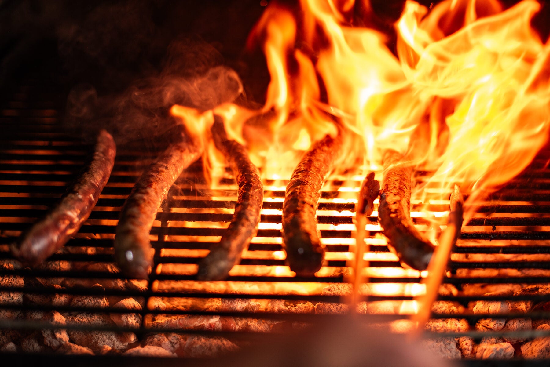 Boerewors on an open flame charcoal grill